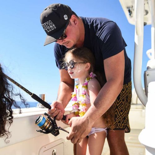 Father and keiki working the rod together on a Ko Olina fishing charter