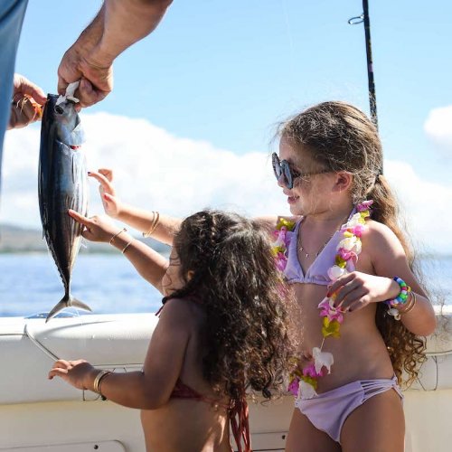 Keiki admiring a fresh aku caught aboard The VENTURE Boat off Ko Olina